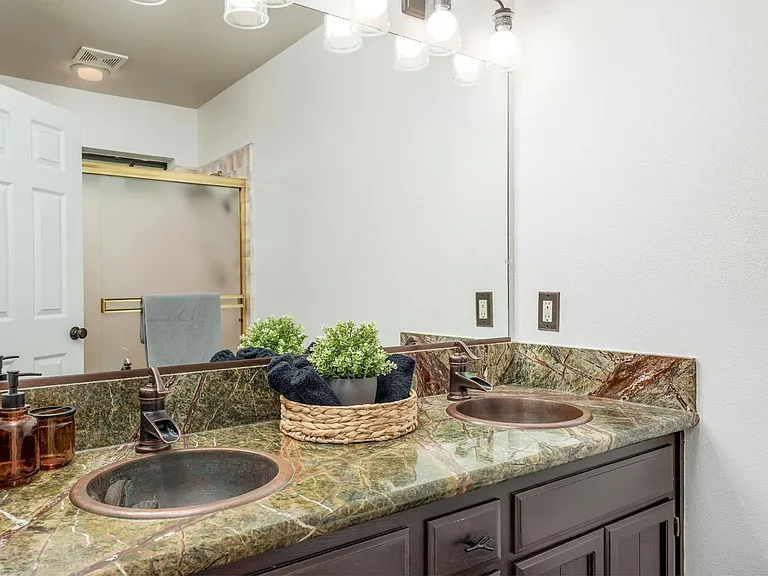 Primary bedroom ensuite with dual copper sinks and walk in shower