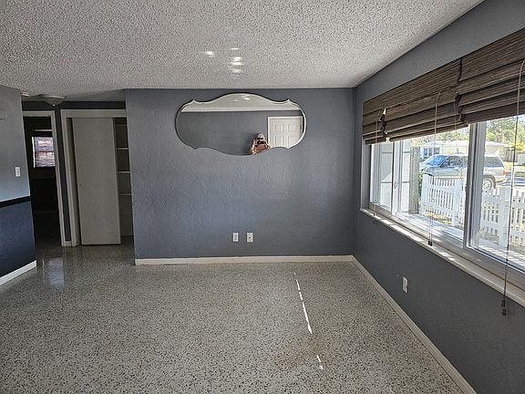 This house boasts TWO large shared rooms. The living room is pictured here. Large windows lend to the indoor/outdoor Florida living in the spring and fall. Large trees help shade the house in the summer.