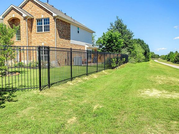 View of the hedge along the iron fence, tall trees and how pretty the trail is for your enjoyment.