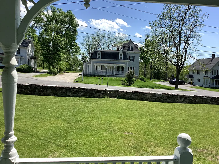 View from small bistro/cafe table for tenant on front porch. View to stone wall & quiet village street.
