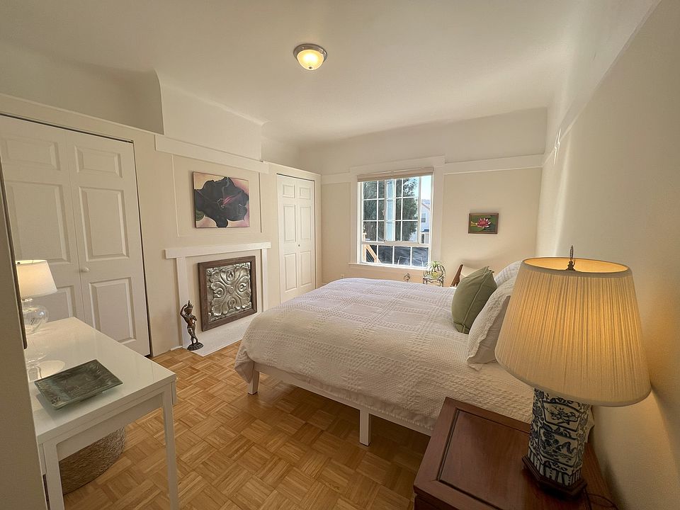 Rear bedroom with west facing window, two closets, queen bed, desk and mirror.