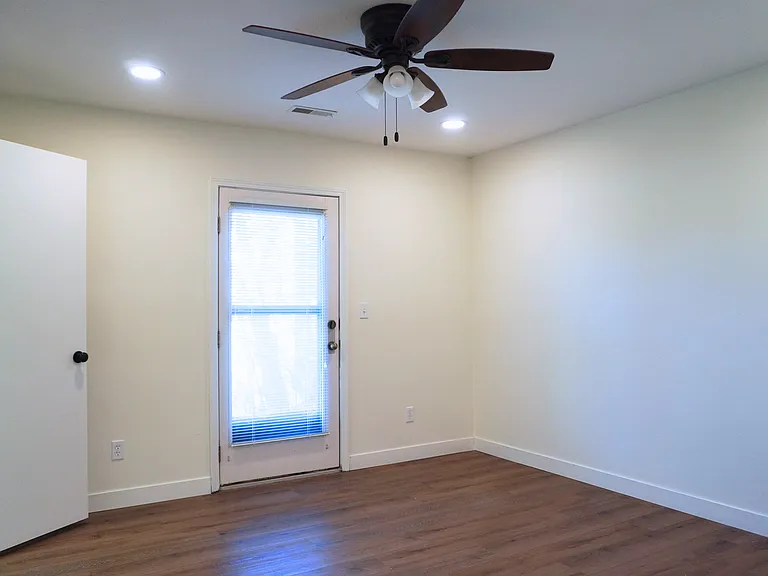 Spacious master bedroom featuring a walk-in closet and a private entry door leading to the outside patio.