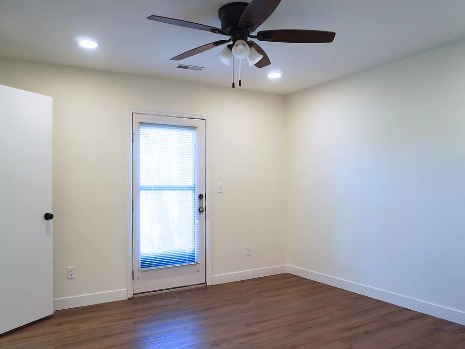 Spacious master bedroom featuring a walk-in closet and a private entry door leading to the outside patio.