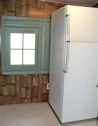 This kitchen features rustic wood-sided walls.