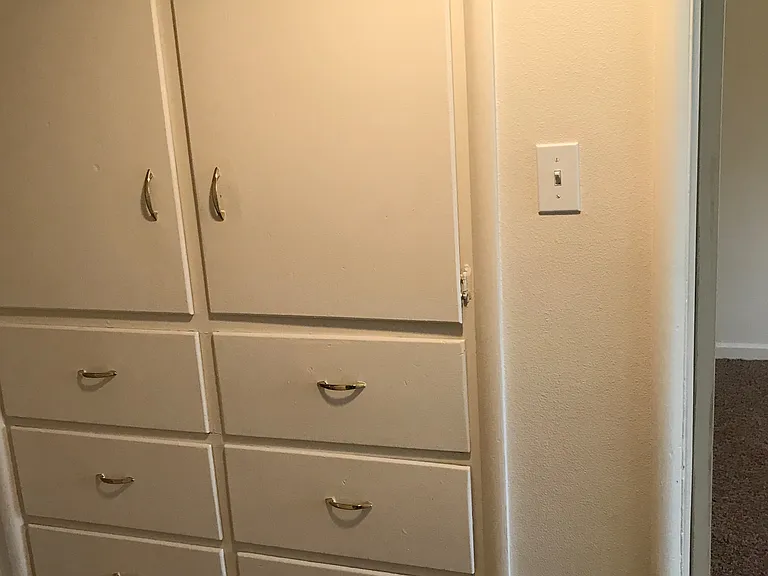 Hallway Storage. An additional 2 1/2 feet of space can be seen above open cabinet doors.