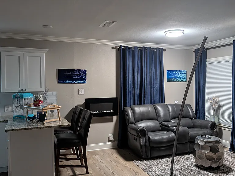 A convenient counter serves as a seamless transition between the living room and the kitchen. It's a perfect spot to enjoy a dinner and movie. It is another option for a work space. On the other side, it serves as food prep station.