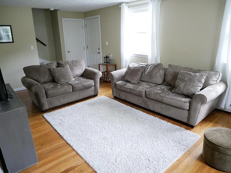 Living room. In background: Front entry, closet & stairway to beds and full bath upstairs.