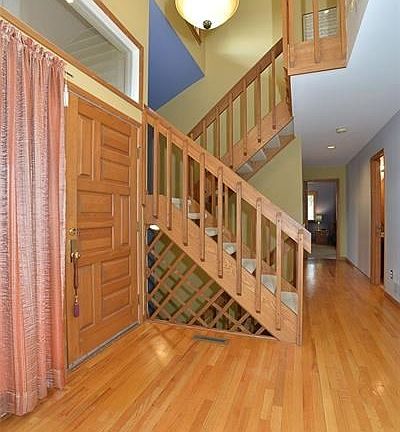 The sun filled two story entry  with hardwood floors and an open staircase to the second floor and lower level is impressive and