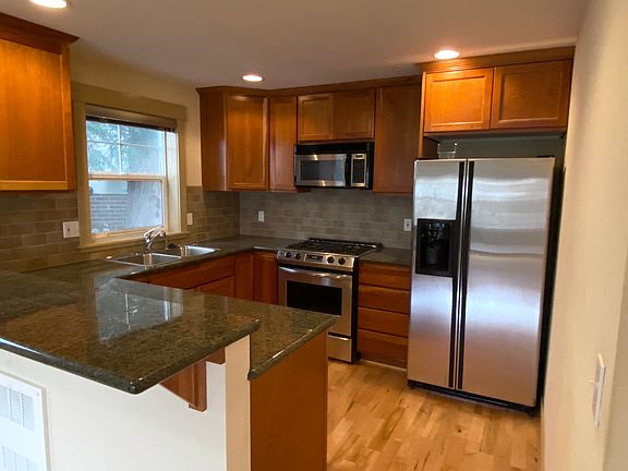 Kitchen with granite, stainless appliances, gas cooking.