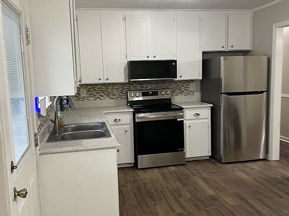 Kitchen with stainless steel appliances. View while standing in SPACIOUS dining area