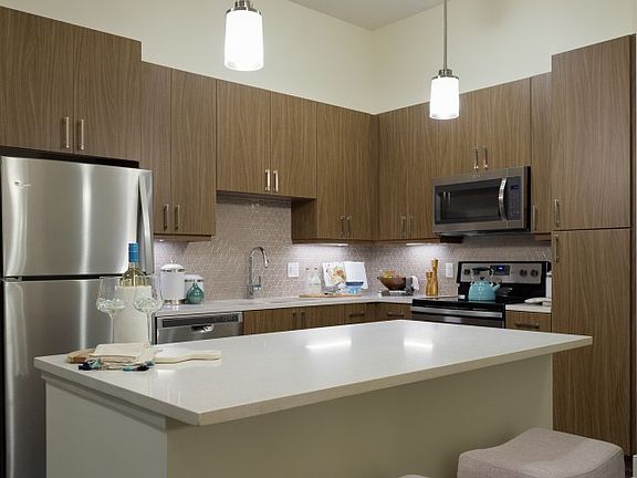 Dark finish kitchen with massive cream quartz countertop isl