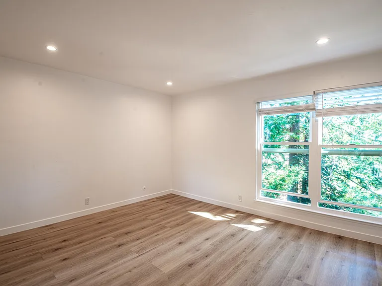 Primary bedroom - view from your private hallway and entrance into your bedroom portion of your suite showcasing the double large windows w/screens and lovely tree tops at the other end of the unit.
Super quiet and serene.