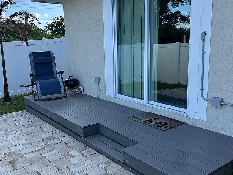 Charming entry with chair, stair access, white fence, and lovely view.
