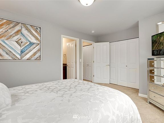Master bedroom with attached bathroom and a closet with lot of space and in-built organization.