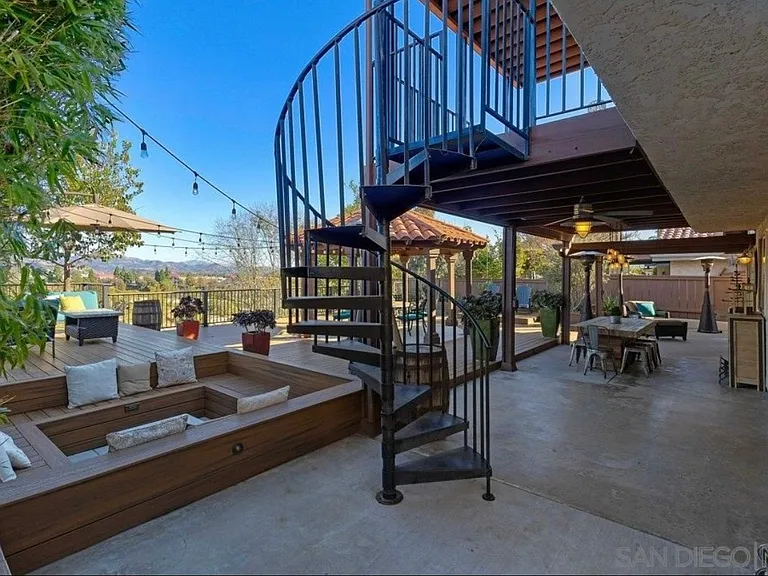 A dramatic spiral staircase connects the primary suite balcony directly to this incredible outdoor retreat.