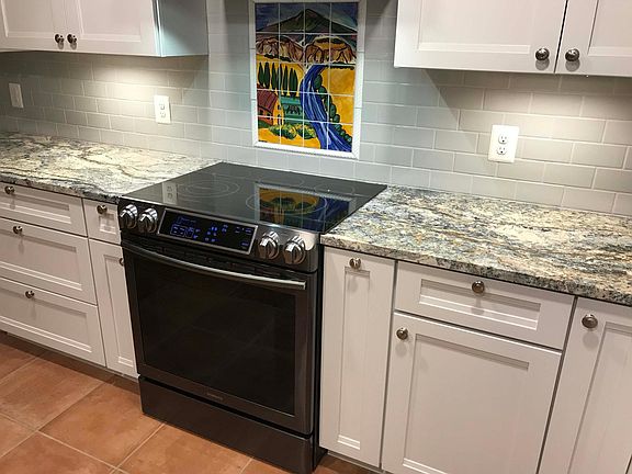 Hand-painted tile from Santa Fe is a focal point in the kitchen and harmonizes with the granite.