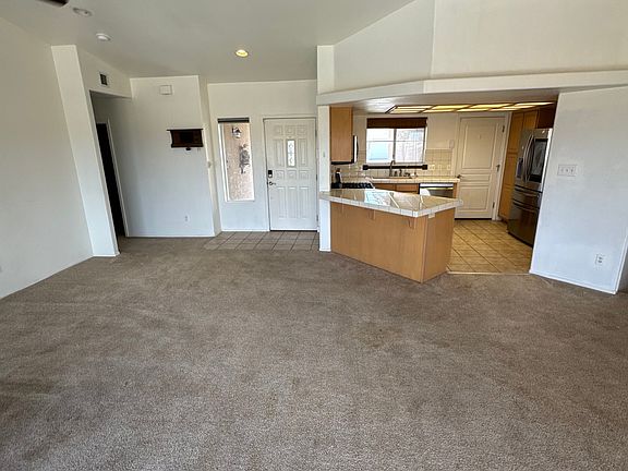 As you enter the home, you're greeted by an open view through the back sliding door, creating a bright and welcoming atmosphere. The kitchen leads directly to the garage, while a hallway to the left takes you to two guest bedrooms and a full guest bath.