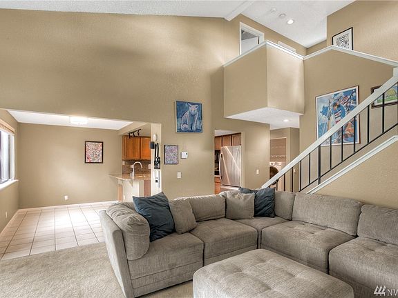 Living room opens to kitchen with eating space and open rail banister offers nice detailing.