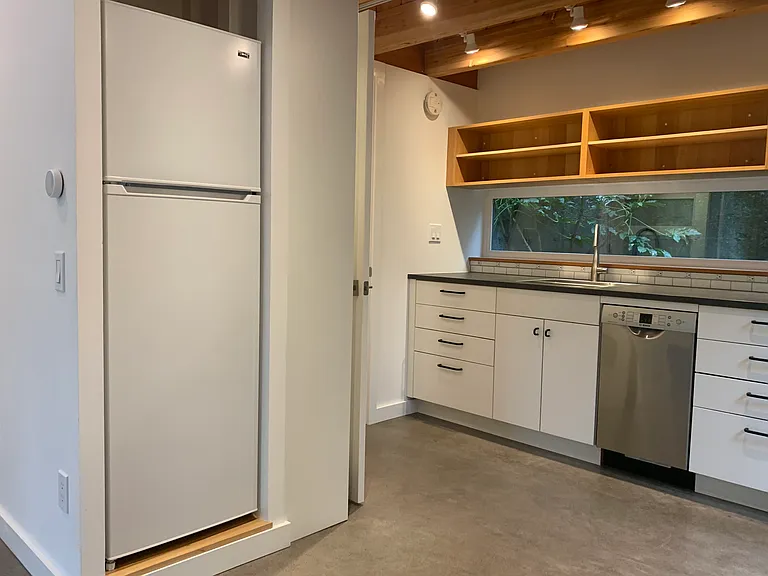 Kitchen with refrigerator to the left.