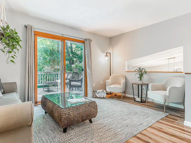 Upper level living room with sliding glass door leading out to upper level of multi-level deck