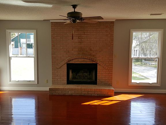 Living room with wood-burning fireplace and built-in cabinets