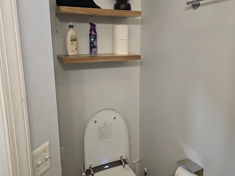 remodeled bathroom with new smart toilet and functional shelving
