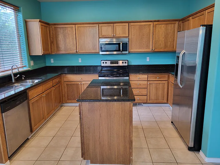 Kitchen with island and plenty of cabinets and slab granite counter tops