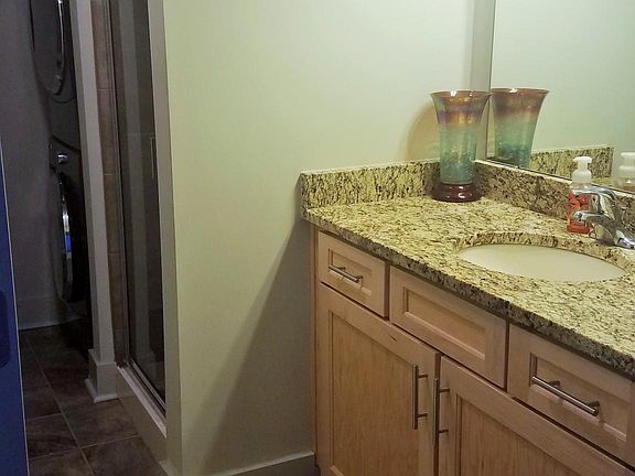 Downstairs bathroom has stacked washer and drier and shower.
