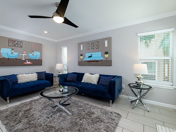 Spacious living room with couch, fireplace and flat screen TV with natural light.