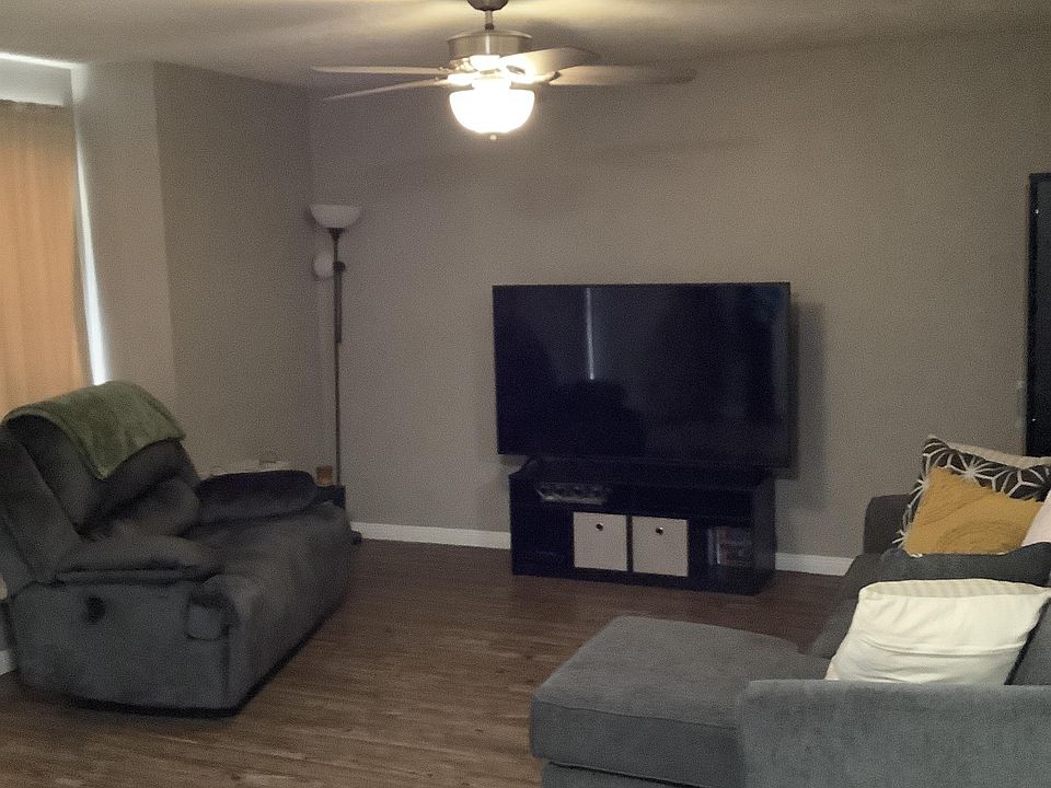 Spacious living room with wood laminate floor and new ceiling fan