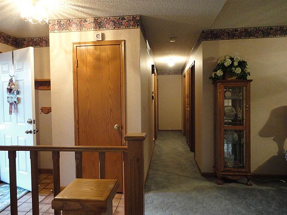 Foyer area with tile, hall closet and view of hallway to the 3 bedrooms and hall bath.
