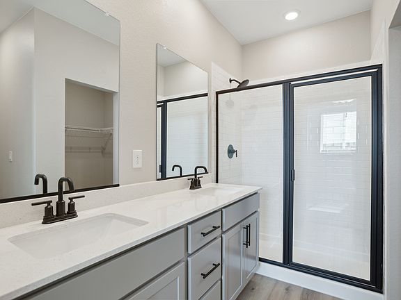 The master bathroom has a dual sink vanity and a step in shower.