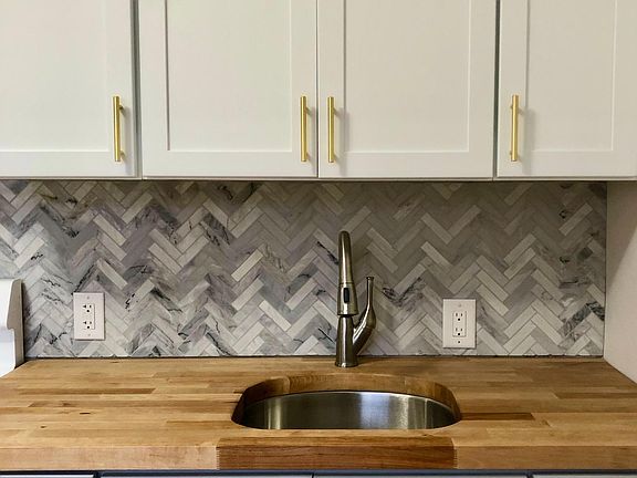 Marble herringbone tile backsplash