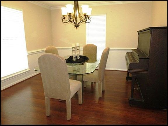  Formal dining room has wood laminate floors, crown molding, chair rail.