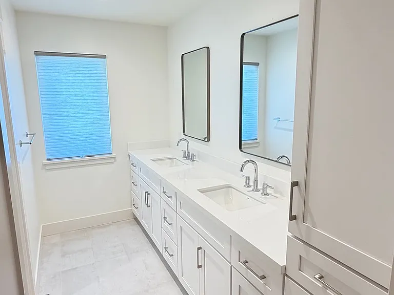 Large hall bath with double sink vanity, private water closet, and walk-in shower.