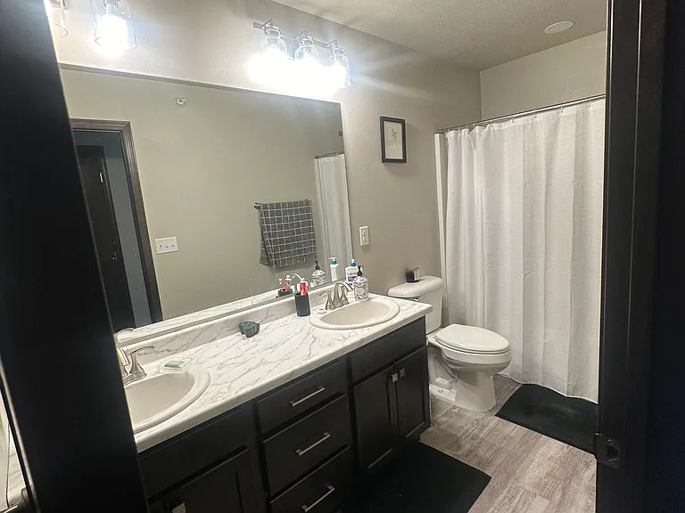 Upstairs bathroom that includes a tub and equipped with dual sinks.