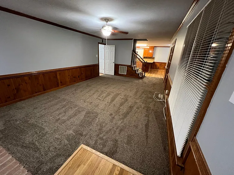 Photo from Family room looking into kitchen and stairwell straight ahead, door to entry way to the left, and double doors to the florida room on the right.
