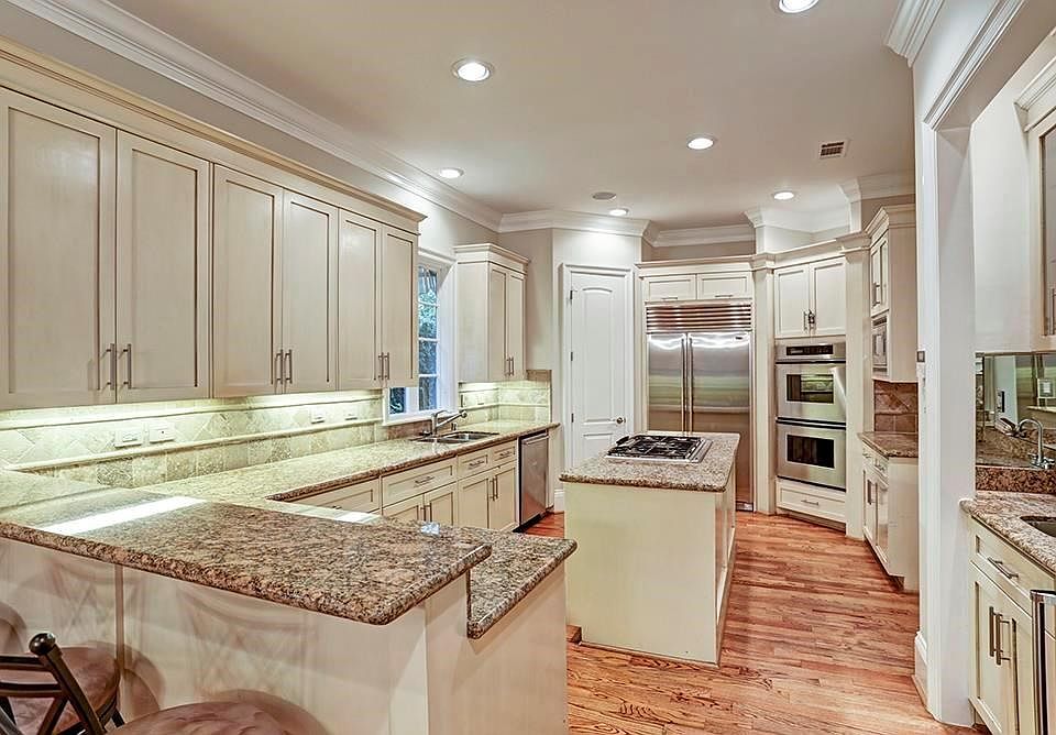 Granite island kitchen has plenty of storage, a breakfast bar and a walk-in pantry. SubZero refrigerator, gas cooktop, Thermador double ovens.