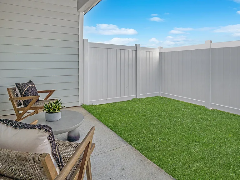 Covered back patio with fenced in yard.