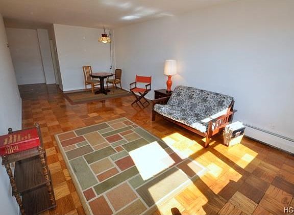 Large sunny living room with dining area and refinished parquet floors.