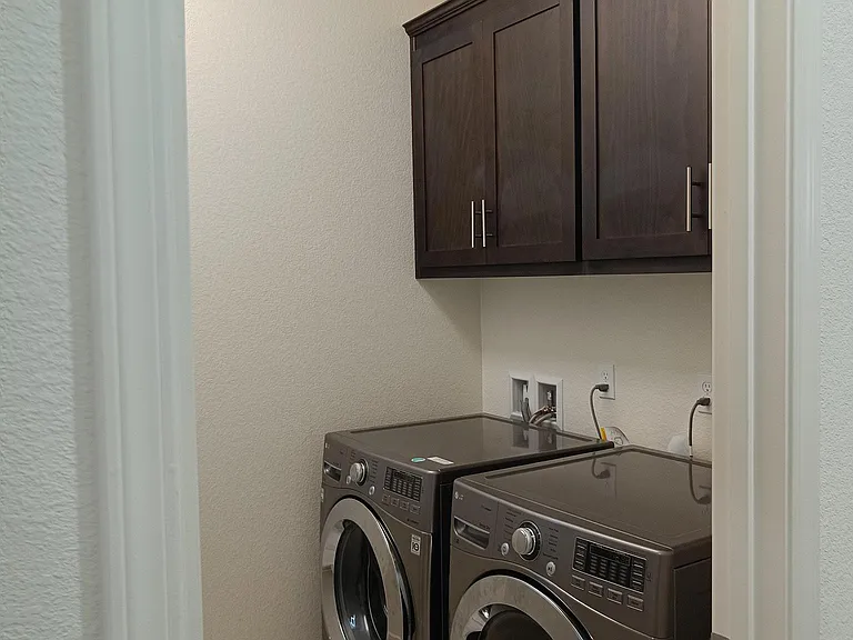Our dedicated laundry room, equipped with a Samsung washer and dryer set. Stay organized with convenient cabinet storage. Laundry day just got an upgrade! __
