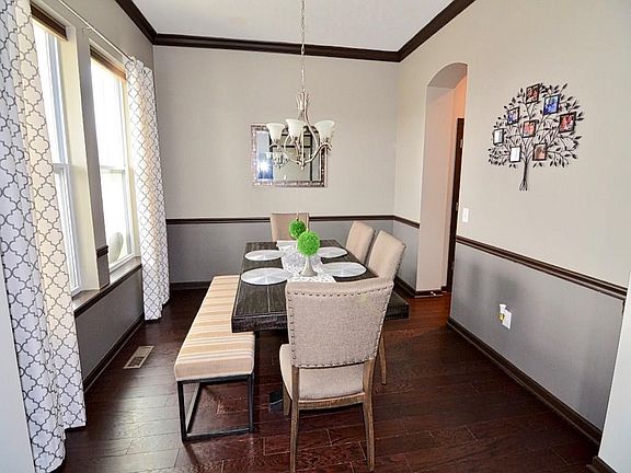 Large dining room with architectural features such as crown molding, chair rail, 11' high ceiling and arched walkway. Wide planked engineered hardwood floors throughout main level.