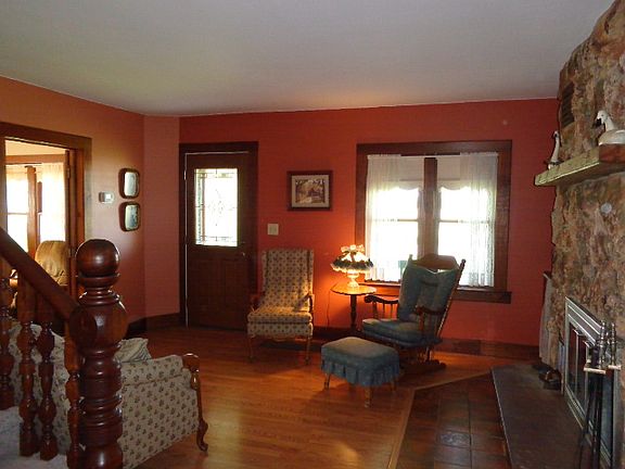 Front door enters into this delightful living room with laminate flooring, a stone fireplace and open staircase to the second level.