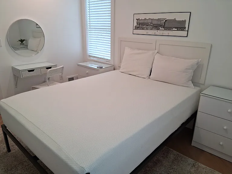 Queen bed with bedside storage and a small desk