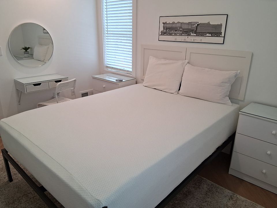 Queen bed with bedside storage and a small desk