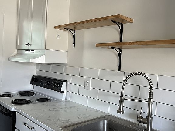 Full-size range, jumbo long/deep sink, commercial-style spray faucet, carrara-style counter, subway tile backsplash
