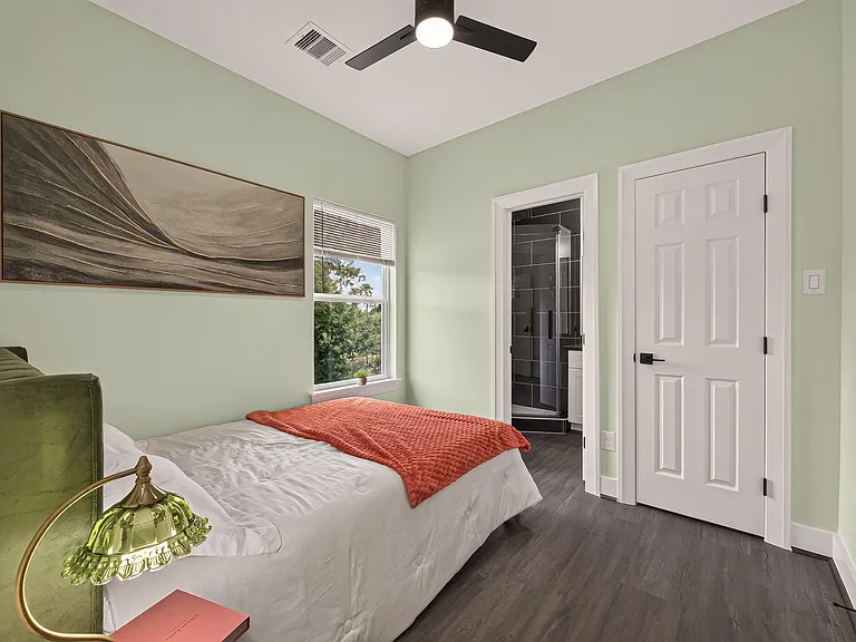 Private bedroom with ceiling fan, window views, and easy access to an adjacent bath; offers comfortable space for daily livin