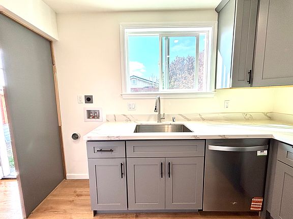 BRAND-NEW kitchen with stainless-steel appliances and flooring.