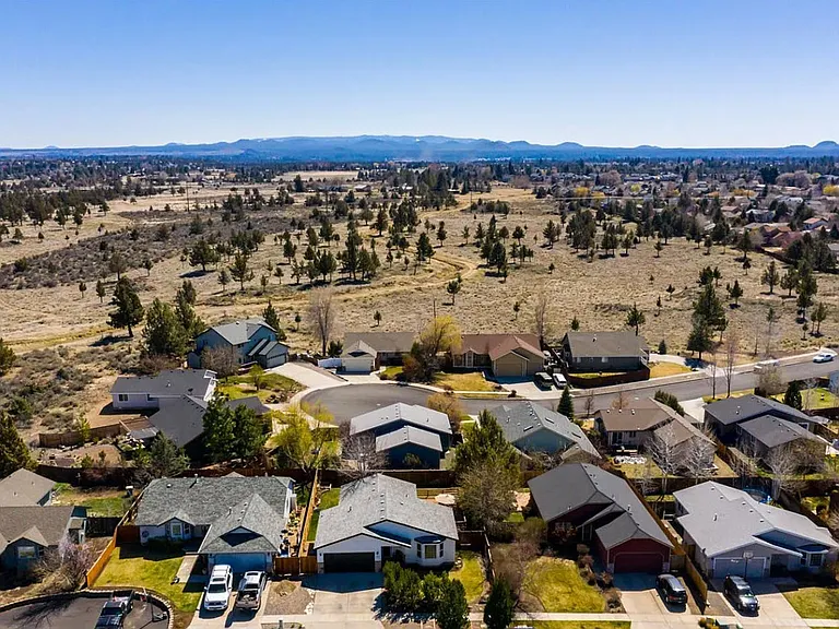 Aerial view of home with open space behind and east of home