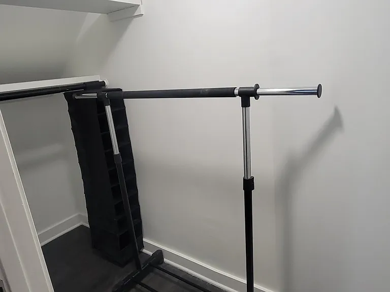 Small walk in closet with extra rolling clothes rack